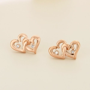 Detailed view of rose gold interlocking heart earrings with sparkling zircon stones