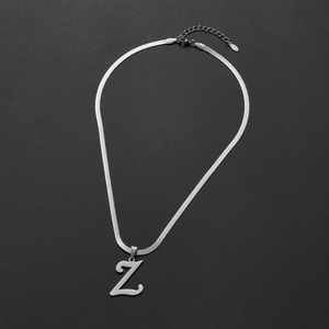 Detailed view of silver capital Z pendant on a smooth snake chain against dark background