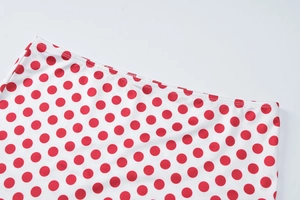 Gros plan détaillé de la taille d'une jupe blanche à pois rouges avec coutures fines