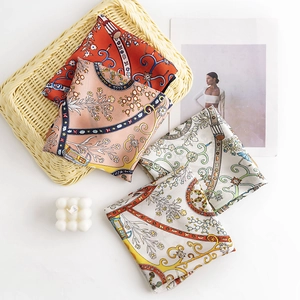 Elegant vintage floral silk-like square scarves in red pink and white on a white desk