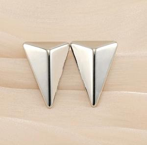 Polished triangle earrings on champagne silk background showing geometric minimalist design