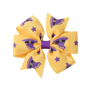 Detail of yellow and purple Halloween bow with stars and wizard hat patterns