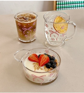 Détail d'un ensemble de verres et bol avec nœuds roses et motifs floraux pour petit-déjeuner