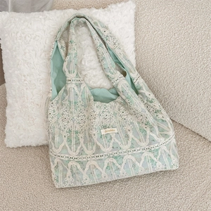 Detailed shot of fresh light green canvas tote with delicate white lace overlay