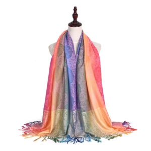 Detail of colorful paisley jacquard scarf with rainbow gradient fringe on model