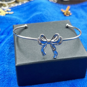 Détail d'un bracelet jonc argenté en acier inoxydable avec nœud sur boîte à bijoux
