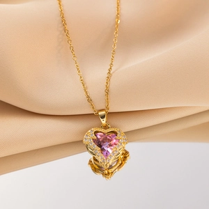 Golden heart necklace with pink amethyst gemstone and crystal halo on satin background