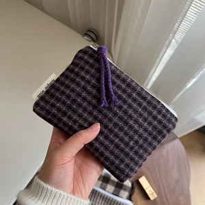 Detail of purple plaid woolen mini pouch with a zipper closure and rope puller