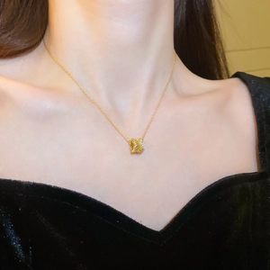 Close-up of a gold cylinder pendant necklace with sparkling pavé crystals for women