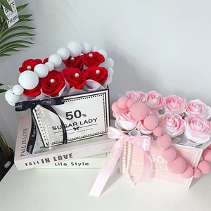 Detail of red and pink artificial soap rose gift boxes with pearls and decorative ribbons