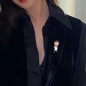 Detail of medical professional brooch with opal accents on black blazer lapel