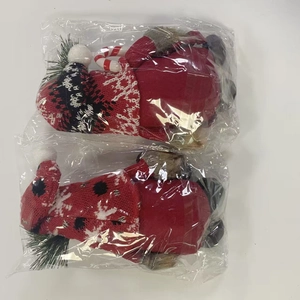 Close-up of two Christmas gnomes in plastic packaging with Merry Christmas knitting
