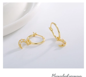 Macro shot of gold-plated hollow moon earrings with micro-inlaid zirconium details