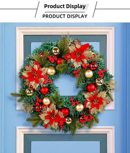 Detail of a large festive Christmas wreath with red poinsettias and gold balls on a blue door