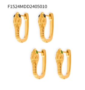 Detail of snake head hoop earrings with emerald and black gemstone eyes in gold finish