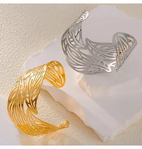 Detailed view of gold and silver hollow leaf pattern titanium steel open bracelets