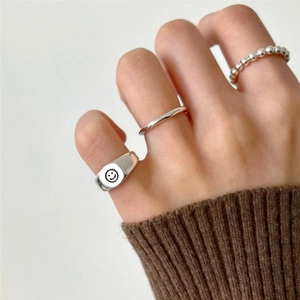 Detailed close-up of a three-piece S925 sterling silver ring set with a smiley face design