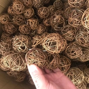Hand holding 5cm natural brown woven rattan balls for Christmas pet toy decorations