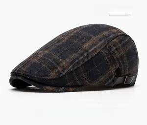 Detail view of navy blue plaid newsboy hat with textured wool and leather strap buckle