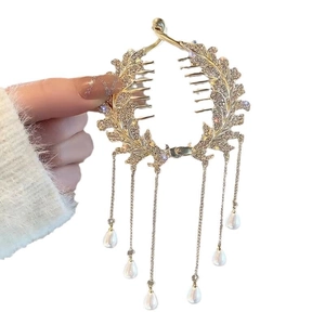 Golden leaf hair clip with rhinestones and long pearl tassels shown in hand