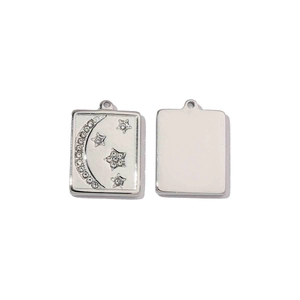 Macro detail of silver rectangular stainless steel pendants with moon and star zircon inlay
