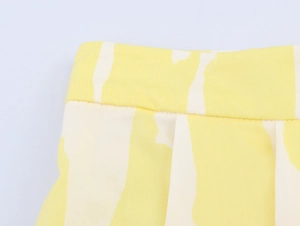 Detailed macro view of high-quality woven yellow and white abstract print midi skirt fabric