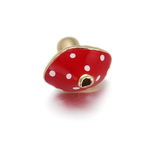 Detail of red enamel mushroom charm with white dots and gold plating for DIY jewelry