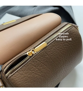Détail de la fermeture éclair dorée sur le sac baguette en cuir grainé marron foncé