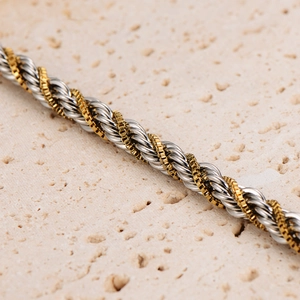 Hiphop two-tone gold and silver twist rope chain with box links on stone background