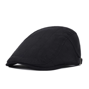 Detail of black flat cap showing cotton texture and adjustable metal buckle strap