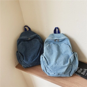 Vintage denim mini backpacks in dark and light blue displayed on a wooden shelf