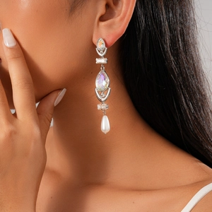 Detailed close-up of a silver drop earring with marquise crystal and hanging pearl