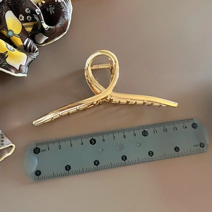 Detail view showing a 11.5cm golden metal shark hair claw clip with measuring ruler