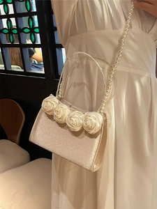 Elegant champagne champagne pearl handbag featuring handmade satin roses and pearl handle