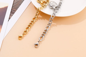 Close-up of gold and silver heart pendant thick chain bracelets on a decorative plate