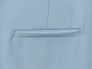 Dettaglio del tessuto twill azzurro e cuciture precise della tasca sui pantaloni