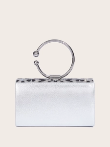 Detailed view of silver evening bag with sparkling rhinestone patterns and metal ring handle