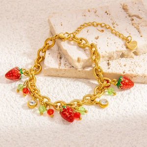 Close-up of golden stainless steel chain bracelet with red strawberry enamel charms