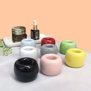 Colorful ceramic toothbrush holders set in various candy colors on a flat surface