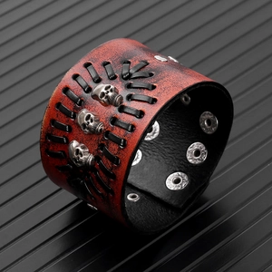 Detail view of brown leather punk bracelet with braided cords and silver skull rivets