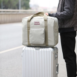 Grey Oxford folding travel bag on silver luggage handle for easy transport