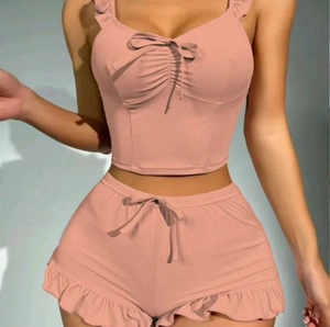 Pink ribbed two-piece set featuring camisole top with bow and ruffled drawstring shorts