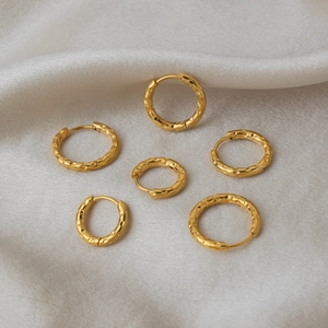 Close-up of three pairs of hammered 18K gold-plated stainless steel hoop earrings