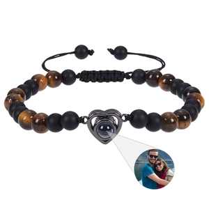 Detail of 6mm matte black stone and tiger eye bracelet with a heart photo projection charm