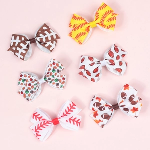 Detail view of six ribbon hair bows with rugby and baseball sports themed patterns