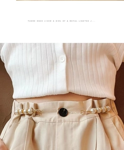 Detail of elegant pearl and rhinestone waist buckles on khaki pants for styling