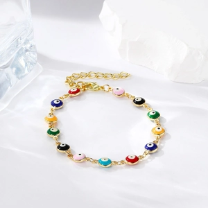 Detail of colorful enamel evil eye charms on a gold adjustable chain bracelet