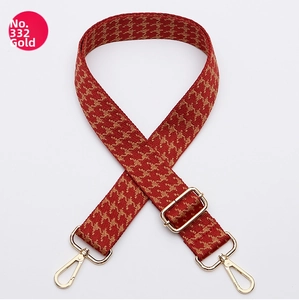 Detail of red and gold houndstooth wide bag strap with adjustable gold metal hardware