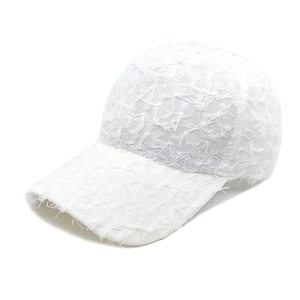 Detail of white baseball cap featuring unique fringe texture and breathable lace fabric