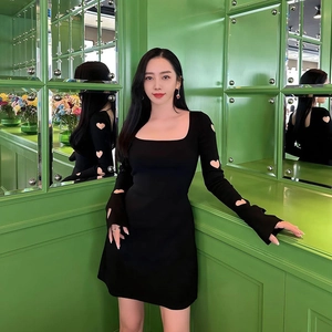 Dettaglio dei ritagli a forma di cuore sulle maniche del vestito nero in maglia